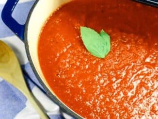 Tomato sauce garnished with fresh basil in pot