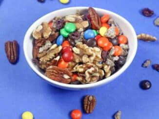 Low Sodium Homemade Trail Mix in a white bowl on a blue surface.