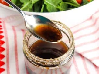 balsamic vinaigrette in a clear jar, salad in background