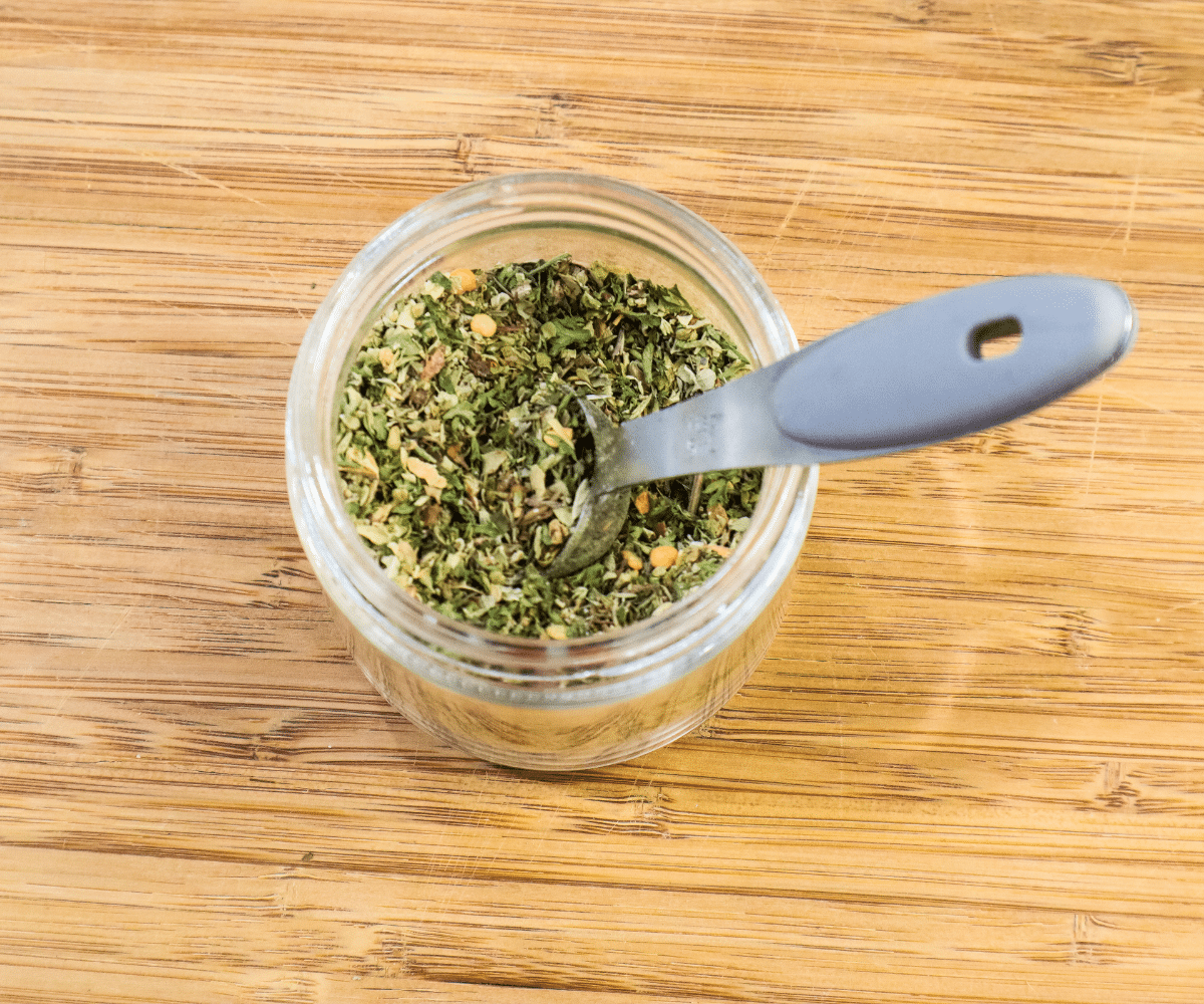 spice blend in small glass jar with measuring spoon